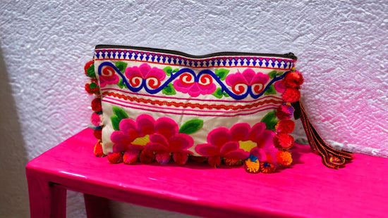 Neon pink blossom on white with multi-coloured pom pom clutch
